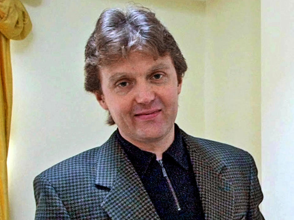 FILE - Alexander Litvinenko, a former KGB spy and critic of Russian President Vladimir Putin, poses for photo at his home in London, on Friday, May 10, 2002. Litvinenko was seen as a traitor by the Kremlin after defecting from Russia in 2000 and fleeing to London. He was poisoned with tea laced with radioactive polonium-210 in a London hotel. On his deathbed, Litvinenko claimed Putin directly ordered his assassination. A British inquiry later found that Russian agents had killed Litvinenko, probably with Putin's approval. (AP Photo/Alistair Fuller, File)