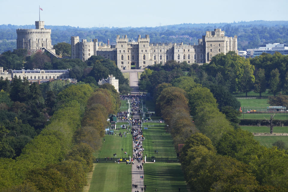 People make their way along the Long Walk towards Cambridge gate outside Windsor Castle to lay flowers for the late Queen Elizabeth II in Windsor, England, Sunday, Sept. 18, 2022. The Queen will lie in state in Westminster Hall for four full days before her funeral on Monday Sept. 19. (AP Photo/Gregorio Borgia)