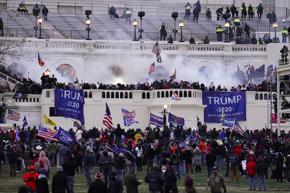 FILE - In this Wednesday, Jan. 6, 2021, file photo, violent protesters storm the Capitol, in Washington.  People charged in the attack on the U.S. Capitol left behind a trove of videos and messages that have helped federal authorities build cases. In nearly half of the more than 200 federal cases stemming from the attack, authorities have cited evidence that an insurrectionist appeared to have been inspired by conspiracy theories or extremist ideologies, according to an Associated Press review of court records. (AP Photo/John Minchillo, File)