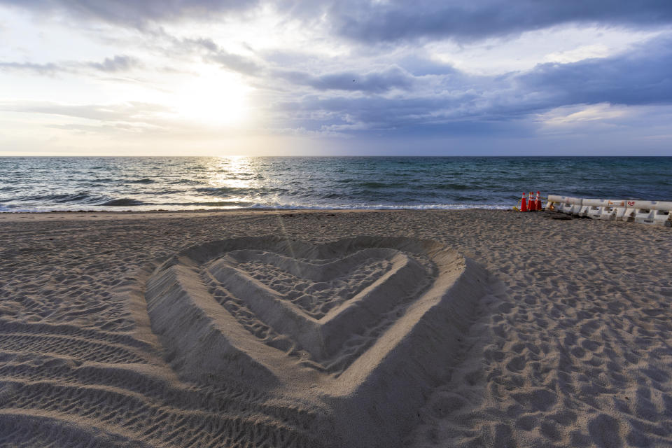 SURFSIDE, FLORIDA - JULY 05: The shape pf heart on the beach sand located near the partially collapsed 12-story Champlain Towers South condo that was taken down with a controlled demolition on July 5, 2021 in Surfside, Florida. The decision by officials to bring the rest of the building down was brought on by the approach of Tropical Storm Elsa and fears that the structure might come down in an uncontrolled fashion. Over one hundred people are missing as the search-and-rescue effort continues. (Photo by Saul Martinez/Getty Images)