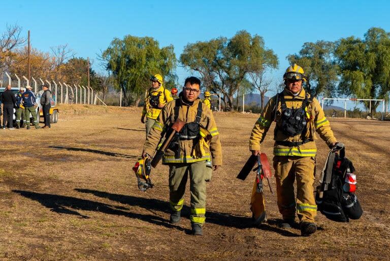 Los bomberos suben en helicóptero y caminan hasta cinco horas para llegar a la zona del incendio