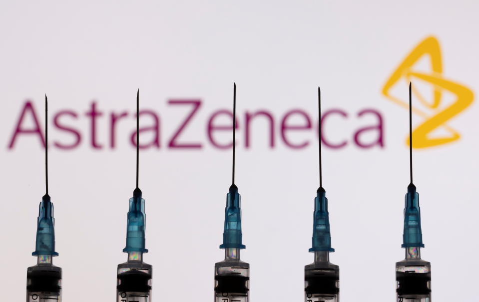 Syringes with needles are seen in front of a displayed AstraZeneca logo in this illustration taken, November 27, 2021. REUTERS/Dado Ruvic/Illustration
