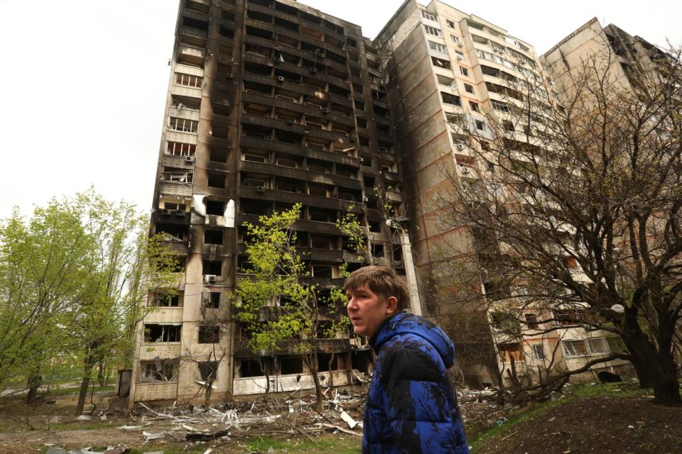 Man outside war-damaged building