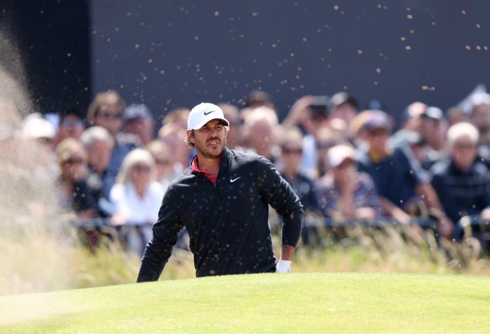 Koepka watches his shot from a bunker