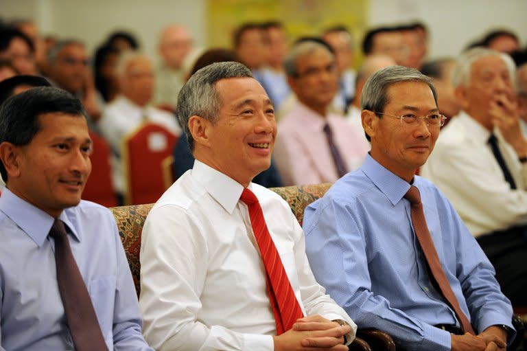 Singapore Prime Minister Lee Hsien Loong (centre) attends a book launch at the Istana Presidential Palace in Singapore on August 6, 2013. Singapore Prime Minister Lee Hsien Loong's efforts to connect with younger voters may finally pay off after a photo of him doing his first fist bump went viral on Facebook