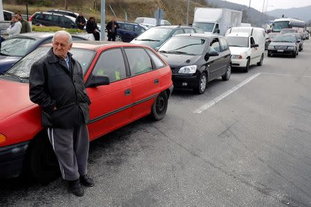 A man waits next to a car near the Promachonas border crossing between Greece and Bulgaria, Greece February 17, 2016. REUTERS/Stoyan Nenov