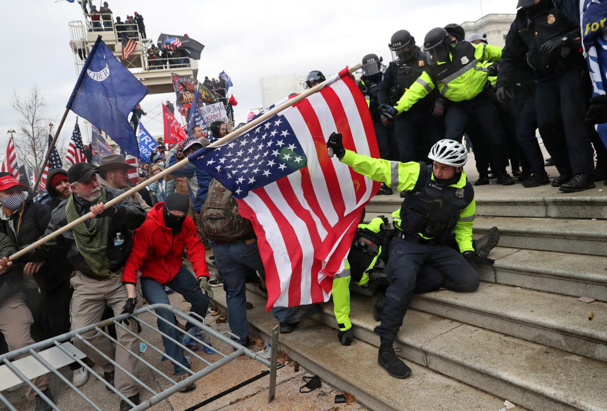 Members of U.S. Capitol Police try to fend off a mob of supporters of U.S. President Donald Trump as one of them tries to use a flag like a spear as the supporters storm the U.S. Capitol Building in Washington, U.S., January 6, 2021. Picture taken January 6, 2021. REUTERS/Leah Millis