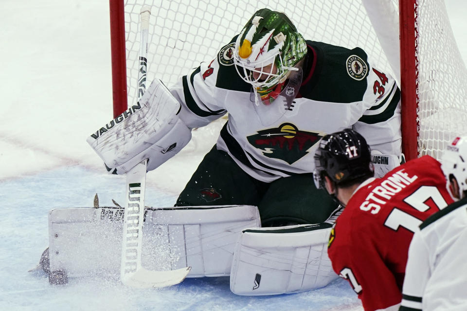 Minnesota Wild goaltender Kaapo Kahkonen, left, makes a save on Chicago Blackhawks center Dylan Strome during the second period of an NHL hockey game in Chicago, Friday, Jan. 21, 2022. (AP Photo/Nam Y. Huh)