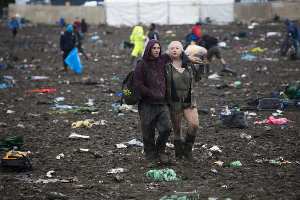 Two muddy music fans make their way out of the festival.