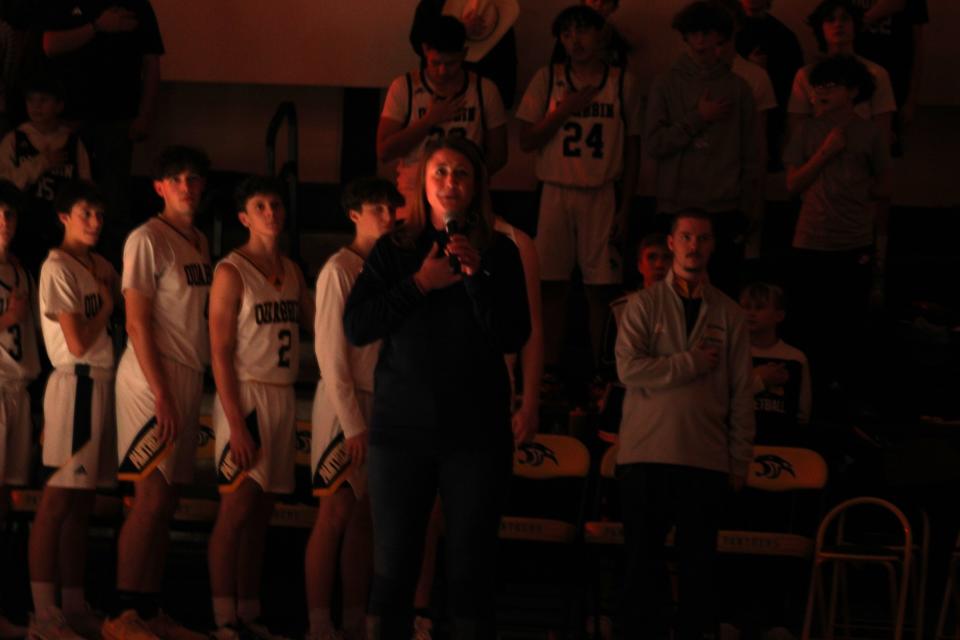 Sara McDougall Sherblom sings the National Anthem at a Quabbin boys basketball game on February 2, 2024 in honor of her singing at the state championship game in 1999. Members of the 1999 team were recognized at halftime of the game.
