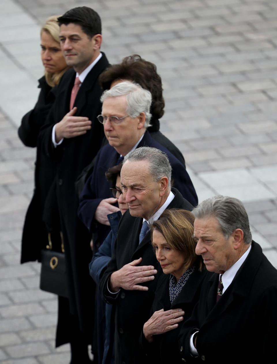 <p>Congressional leaders Speaker of the House Paul Ryan (R-WI), Senate Majority Leader Mitch McConnell (R-KY), Senate Minority Leader Chuck Schumer (D-NY), and House Minority Leader Nancy Pelosi (D-CA) watch as a U.S. military honor guard team carries the flag draped casket of former U.S. President George H. W. Bush.</p>