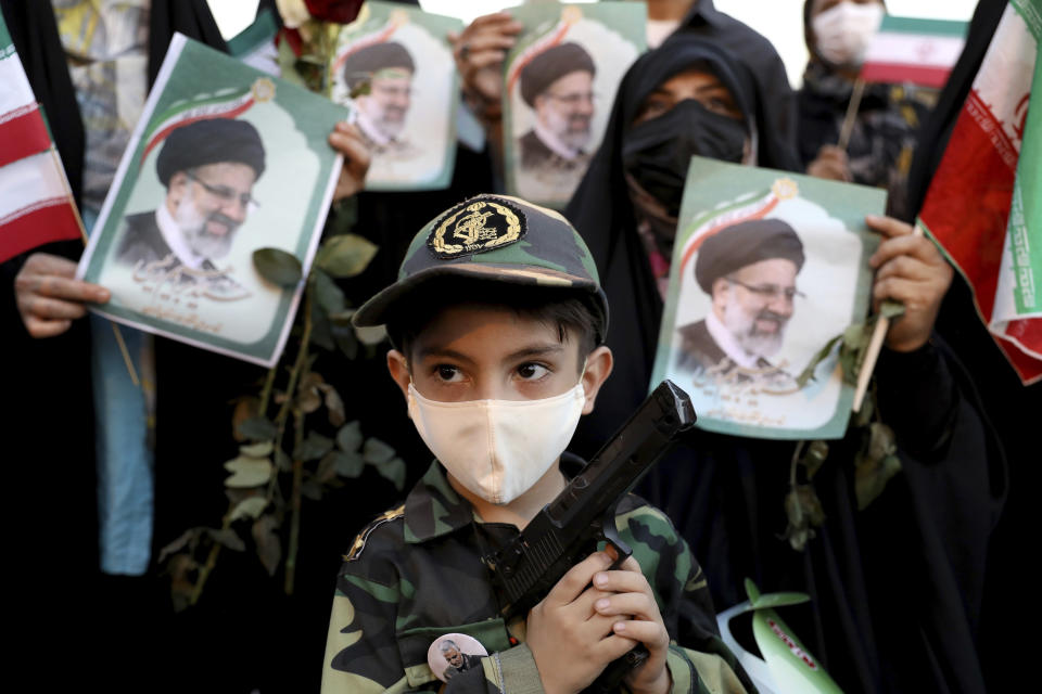 An Iranian kid holds a toy gun as he participate the victory ceremony of Iranian president-elect Ebrahim Raisi after he won the presidential election in Tehran, Iran, Saturday, June 19, 2021. Initial results released Saturday propelled Raisi, a protege of the country's supreme leader, into Tehran’s highest civilian position. The vote appeared to see the lowest turnout in the Islamic Republic’s history. (AP Photo/Ebrahim Noroozi)