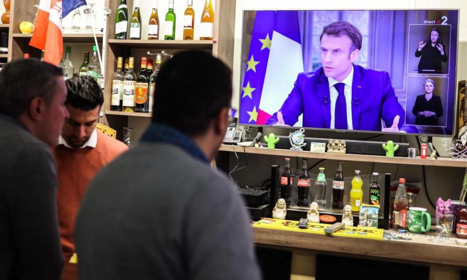 People watch French President Emmanuel Macron’s TV interview from a bar restaurant in Toulouse on Wednesday.