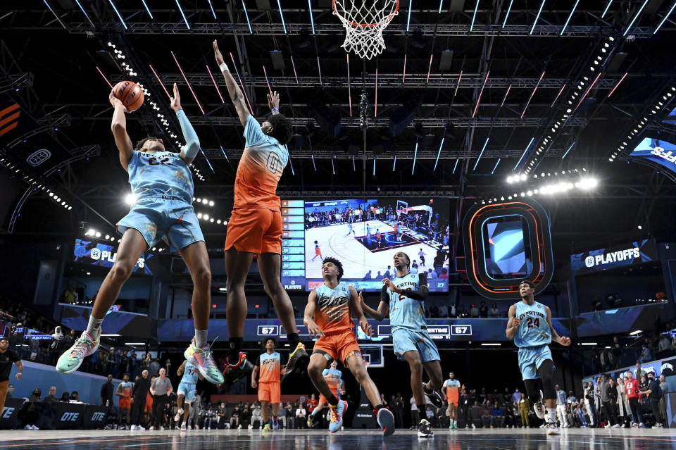 In this photo provided by Overtime Elite, Dominick Barlow, left, shoots for Team Overtime in a game against Team Elite at OTE Arena in Atlanta, Tuesday, March 8, 2022. Barlow will be one of the 76 prospects at the NBA draft combine this week in Chicago. But he didn’t take the conventional route through the college ranks. Or the NBA’s G League Ignite. Or playing overseas. He turned down college offers to receive on-the-job training through Overtime Elite, a new basketball league created to give high school players another path to the pros. He got paid -- a six-figure salary -- as he learned about nutrition, social-media skills, financial literacy and, of course, the art of basketball. (Adam Hagy/Overtime Elite via AP)