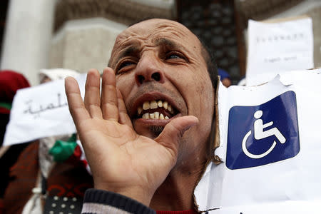A man carries a banner and chants slogans during a protest by people with special needs demanding immediate political change and improvement of their living conditions in Algiers, Algeria March 14, 2019. REUTERS/Ramzi Boudina