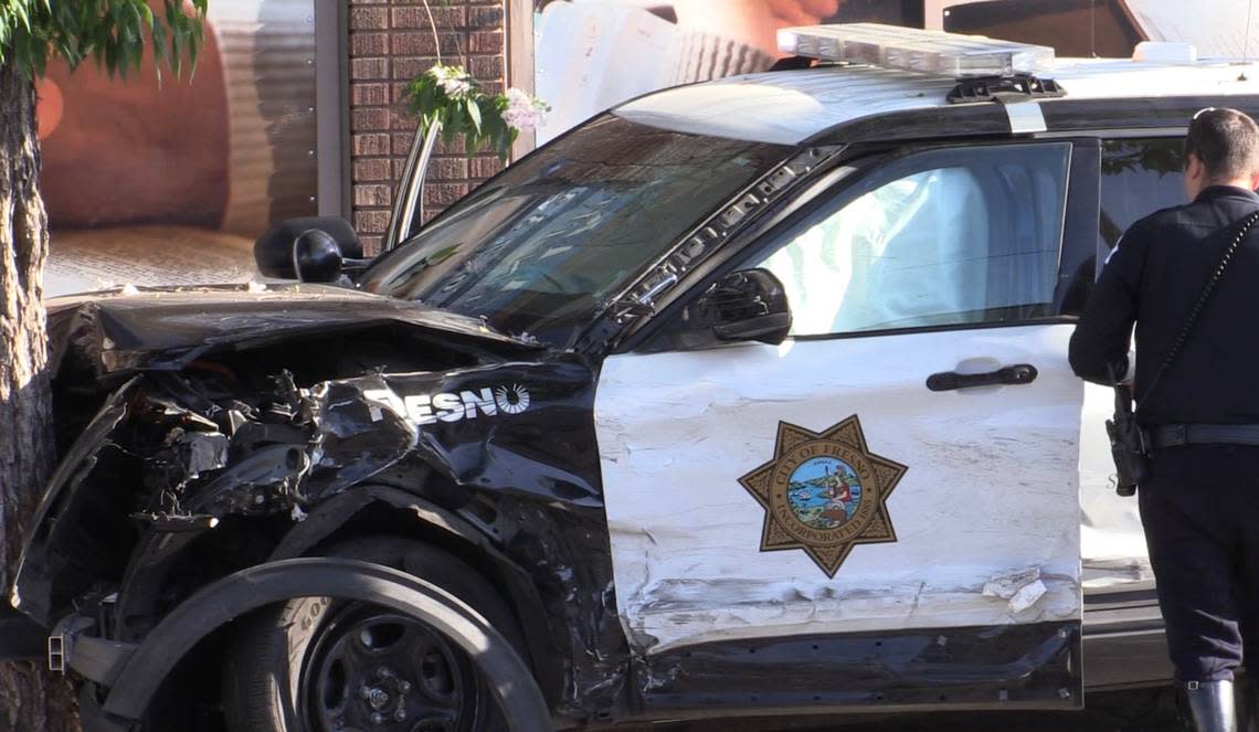 A Fresno police vehicle crashes into a tree after a collision at the intersection of Belmont Avenue and Fulton Street on Saturday, May 20, 2023.