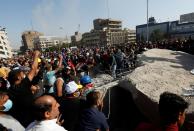 Iraqi demonstrators pull concrete walls at Sinak Bridge during the ongoing anti-government protests, in Baghdad