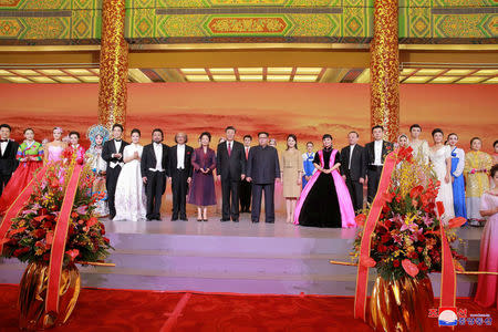 North Korean leader Kim Jong Un and wife Ri Sol Ju, and Chinese President Xi Jinping and wife Peng Liyuan attend a banquet, as Kim Jong Un paid an unofficial visit to Beijing, China, in this undated photo released by North Korea's Korean Central News Agency (KCNA) in Pyongyang March 28, 2018. KCNA/via Reuters