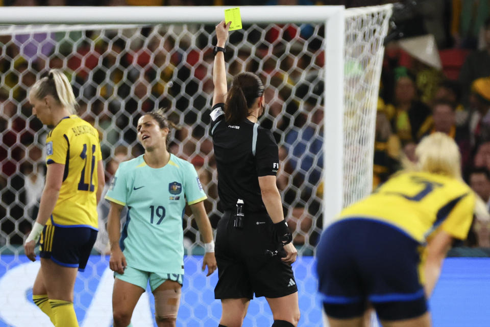 Referee Cheryl Foster shows a yellow card to Australia's Katrina Gorry during the Women's World Cup third place playoff soccer match between Australia and Sweden in Brisbane, Australia, Saturday, Aug. 19, 2023. (AP Photo/Tertius Pickard)