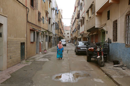 A woman walks along a narrow street in Ouled Moussa district, on the outskirts of Rabat, Morocco April 24, 2018. REUTERS/Youssef Boudlal