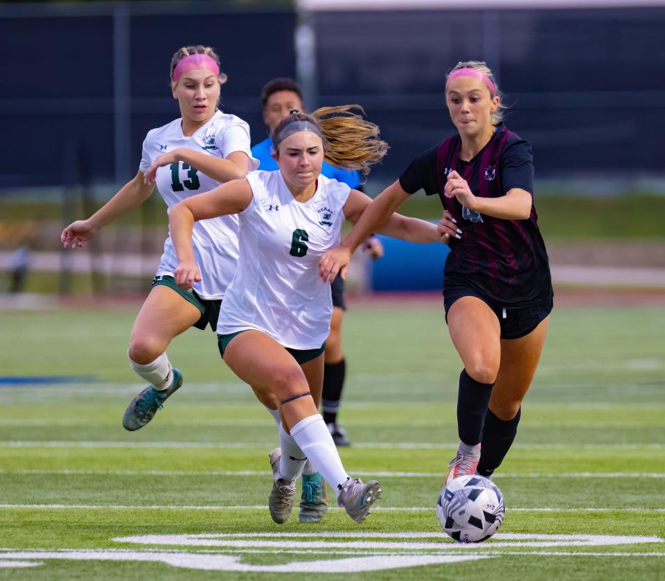 Round Rock's Kara Harris dribbles past San Antonio Reagan's Alyssa Cappuccio during Tuesday night's 2-0 area-round playoff win at Lehman High School. A weather delay helped the Dragons regroup after a slow start to the match.