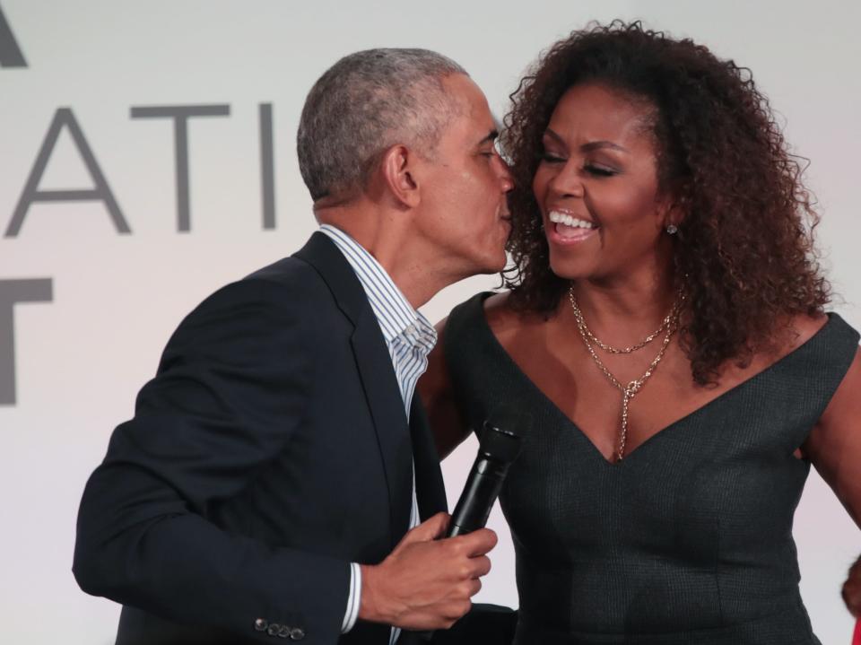 Former President Barack Obama leans in to give his wife, Michelle Obama, a kiss at the Obama Foundation Summit in 2019.