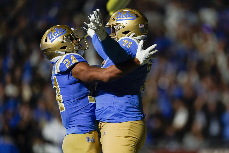 UCLA running back Zach Charbonnet (24) and offensive lineman Raiqwon O'Neal (71) celebrate after scoring a touchdown during the first half of an NCAA college football against Stanford game in Pasadena, Calif., Saturday, Oct. 29, 2022. (AP Photo/Ashley Landis)