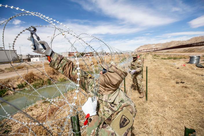 Texas National Guard soldiers put concertina wire on the embankment of the Rio Grande river in El Paso, Texas, in March 2023.