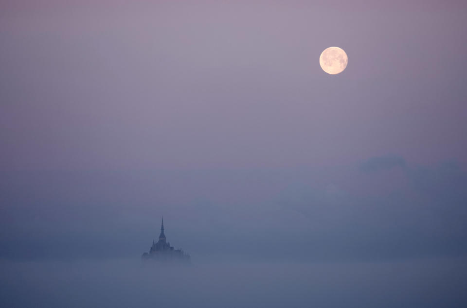 The moon sets above the iconic Mont Saint-Michel in the French region of Normandy, on April 7, 2023. 