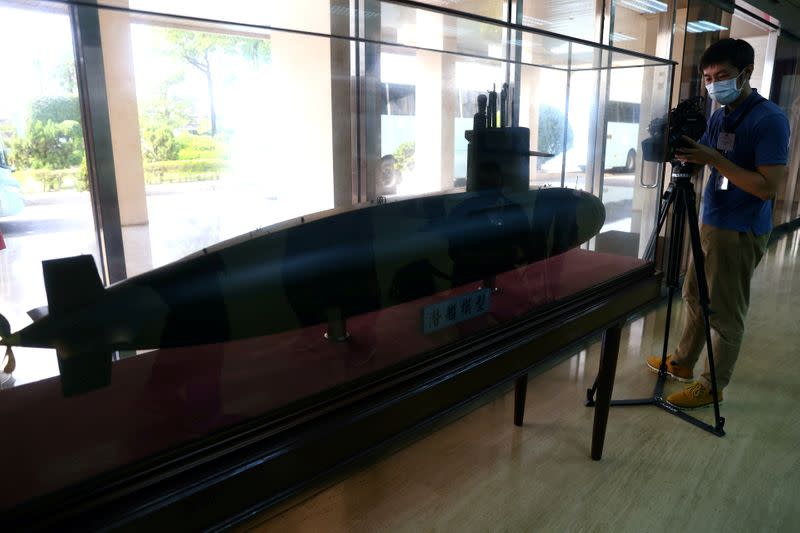 FILE PHOTO: A member of the media takes photos of a Submarine model at the lobby of CSBC Corporation office building in Kaohsiung