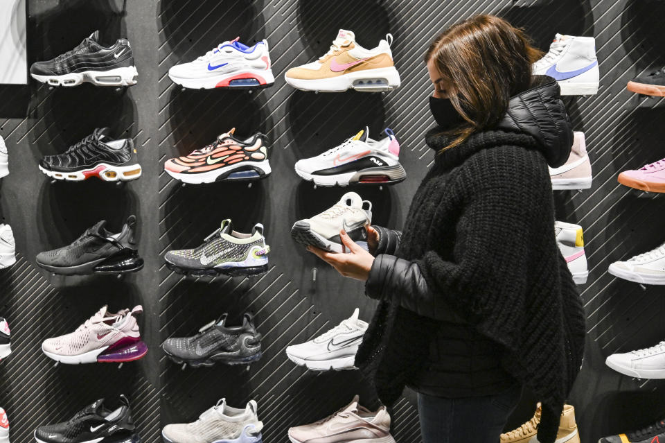 TURIN, ITALY - DECEMBER 06: A person wearing a protective mask chooses shoes inside an Nike store, after reopening on December 06, 2020 in Turin, Italy. Italian regions lowered their COVID-19 measures as contagions are dropping in the whole country and the Government is looking at restraining travels during the Christmas time.  (Photo by Diego Puletto/Getty Images)