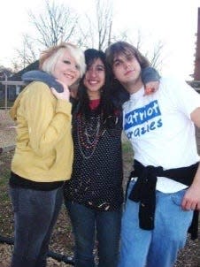 Three friends posing for a photo during a high school reunion.