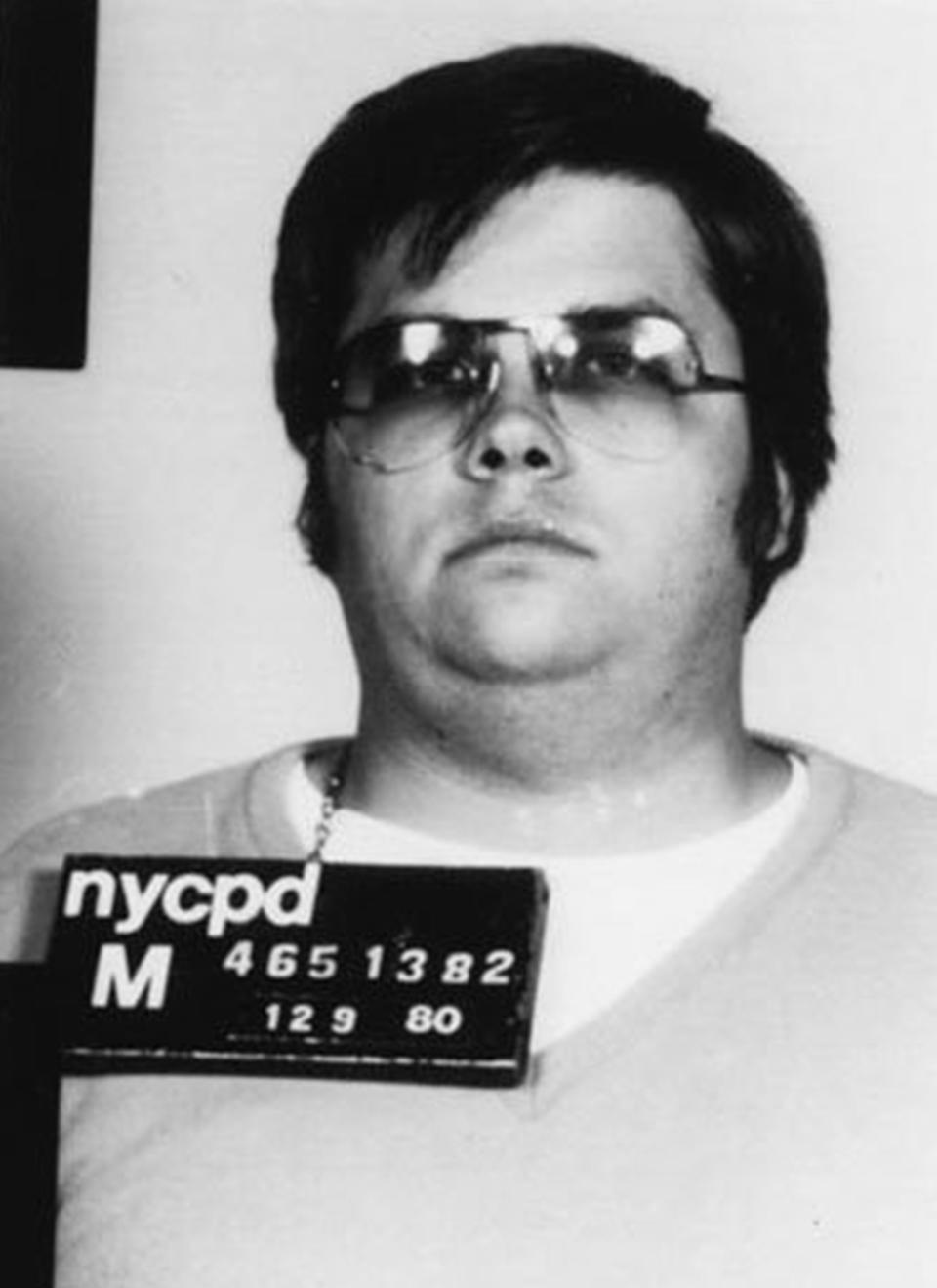 Mark's mug shot wearing dark aviator framed glasses