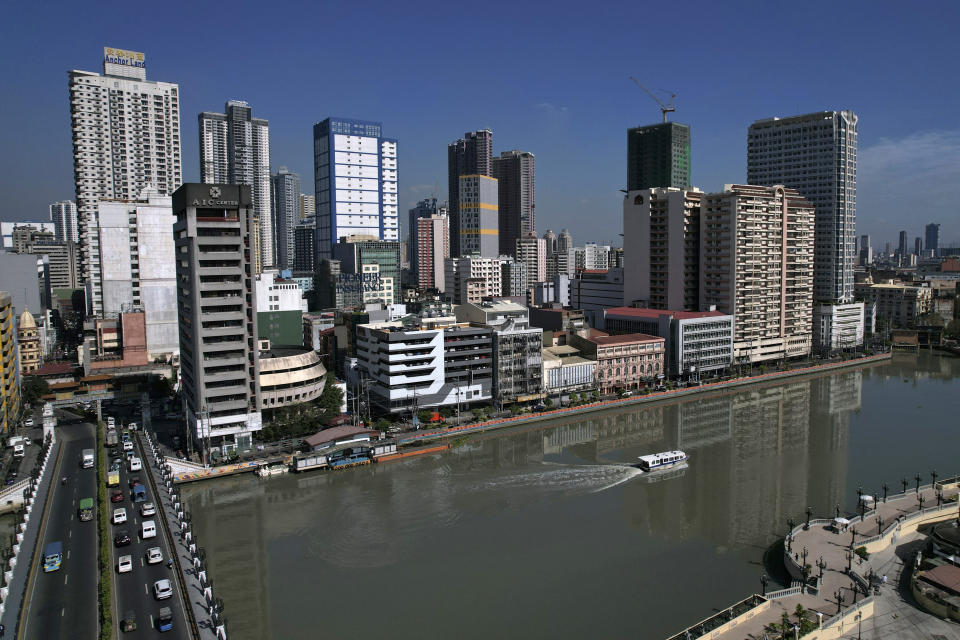 A ferry boat passes by Binondo district, said to be the oldest Chinatown in the world on Wednesday, Feb. 7, 2024, Manila, Philippines. Crowds are flocking to Manila's Chinatown to usher in the Year of the Wood Dragon and experience lively traditional dances on lantern-lit streets with food, lucky charms and prayers for good fortune. (AP Photo/Aaron Favila)