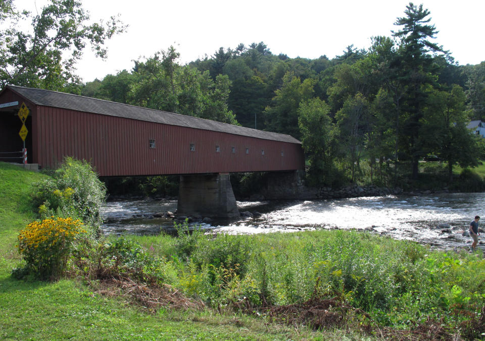 This Aug. 27, 2013 photo shows the wooden covered bridge over the Housatonic River in West Cornwall, Conn. The bridge in Litchfield County, built in the 1860s, is listed on the National Register of Historic Places. (AP Photo/Helen O'Neill)