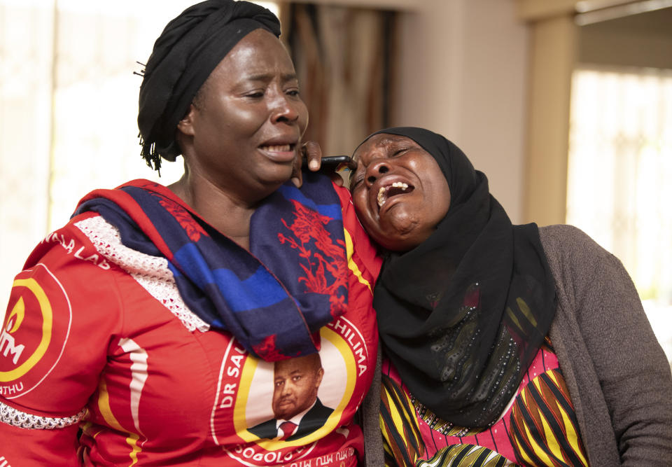 A mourner is comforted in Lilongwe, Malawi, Wednesday , June 12, 2024, following the death of Malawi's Vice President, Saulos Chilima, in a plane crash Monday. The Malawi government says that Chilima will be honored with a state funeral after he was killed along with eight other people in a plane crash. (AP Photo/Thoko Chikondi)