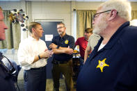 U.S. Rep. Michael Guest, R-Miss., left, speaks with Simpson County Sheriff Paul Mullins and area lawmen at a luncheon with potential voters in Magee, Miss., June 16, 2022, as he seeks support for his runoff race against former Navy pilot Michael Cassidy in the Republican primary of Mississippi's 3rd Congressional District. (AP Photo/Rogelio V. Solis)