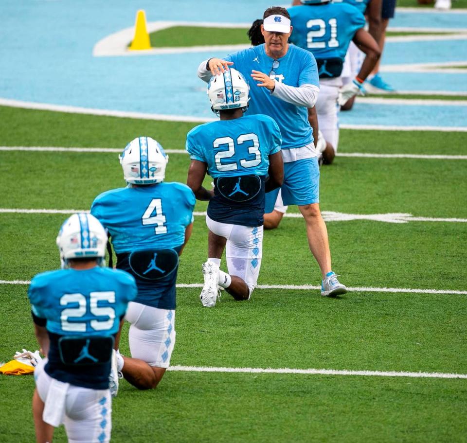 North Carolina assistant head coach for defense Gene Chizik embraces running back George Pettaway (23) during the Tar Heels’ open practice on Saturday, March 25, 2023 at Kenan Stadium in Chapel Hill. N.C.