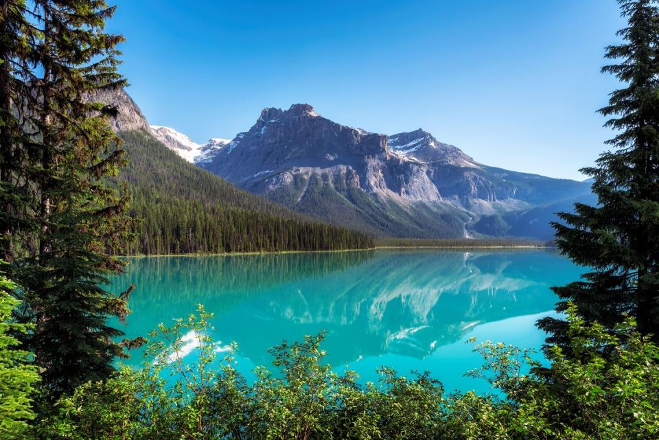 beautiful turquoise waters of the emerald lake with snow covered peaks above it in rocky mountains, yoho national park, canada