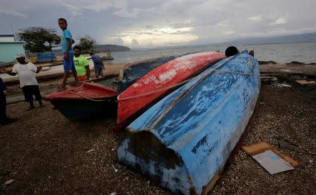 Boats which are secured are seen near residents at Port Royal while Hurricane Matthew approaches, in Kingston, Jamaica October 2, 2016. REUTERS/Henry Romero