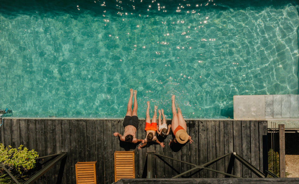 Photo of a young family with two children, relaxing by the pool in a vacation rental villa