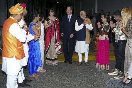 India's Prime Minister Narendra Modi (4th R), Britain's Prime Minister David Cameron (C) and his wife Samantha meet performers in a backstage area during a welcome rally for Modi at Wembley Stadium in London November 13, 2015. REUTERS/Justin Tallis/Pool