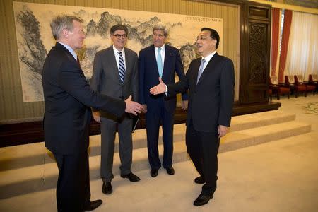 Chinese Premier Li Keqiang (R) reaches out to shake hands with U.S. ambassador to China Max Baucus (L) as U.S. Treasury Secretary Jack Lew (2nd L) and Secretary of State John Kerry watch during a meeting at the Zhongnanhai leadership compound in Beijing July 10, 2014. REUTERS/Ng Han Guan/Pool