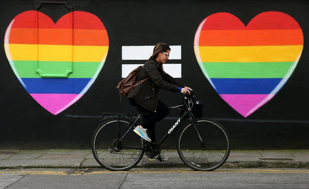 A woman cycles past a marriage equality mural in the Liberties area of Dublin (Brian Lawless/PA) (PA Archive)