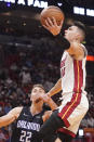 Miami Heat guard Tyler Herro (14) drives to the basket over Orlando Magic forward Franz Wagner (22), during the first half of an NBA basketball game, Monday, Oct. 25, 2021, in Miami. (AP Photo/Marta Lavandier)