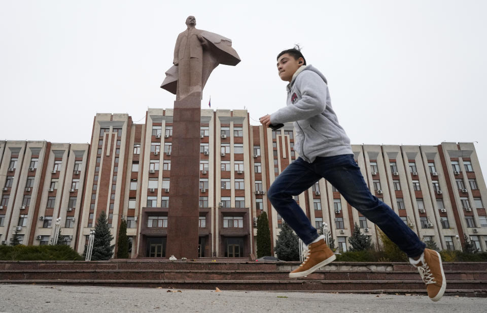 FILE - A boy runs past a statue of Soviet Union founder Vladimir Lenin in Tiraspol, the capital of the Russia-backed breakaway region of Transnistria, in Moldova on Nov. 1, 2021. Since Russia fully invaded Ukraine two years ago, a string of incidents in Transnistria have periodically raised the specter that European Union candidate Moldova could also be in Moscow's crosshairs. (AP Photo/Dmitri Lovetsky, File)