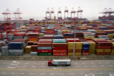 FILE PHOTO: A container truck moves past containers at the Yangshan Deep Water Port in Shanghai, China April 24, 2018. REUTERS/Aly Song/File Photo
