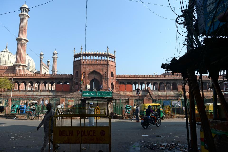 People walk through a partially empty road during a one-day Janata (civil) curfew imposed amid concerns over the spread of the COVID-19 novel coronavirus, near Jama Masjid mosque in the old quarters of New Delhi on March 22, 2020. (Photo by Sajjad HUSSAIN / AFP) (Photo by SAJJAD HUSSAIN/AFP via Getty Images)