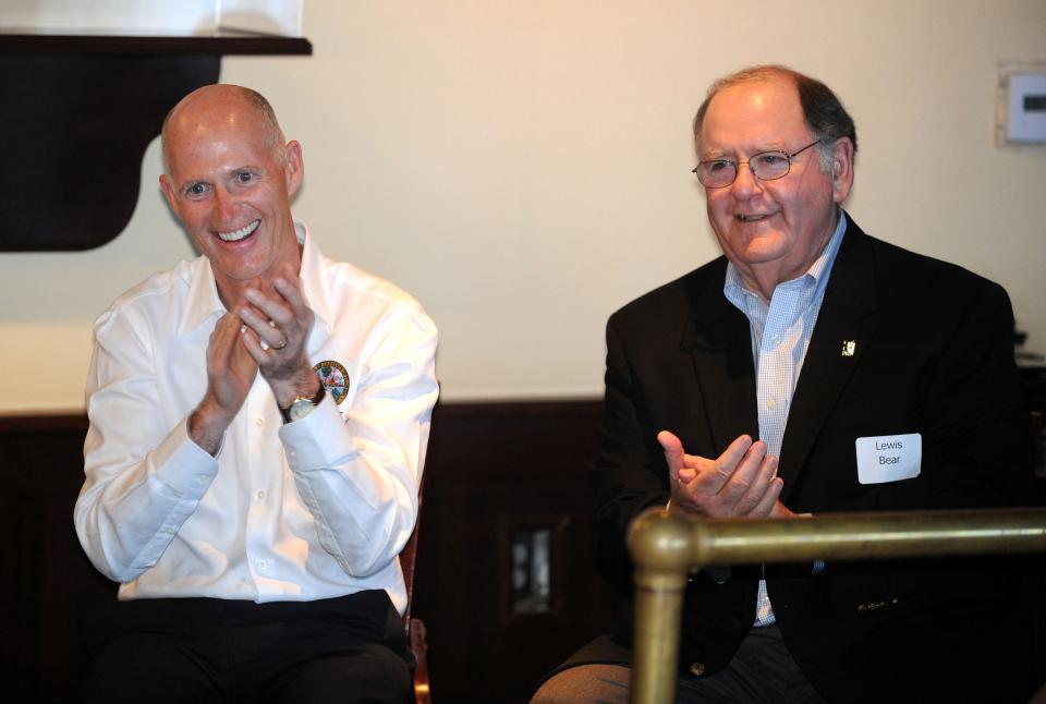 Florida Gov. Rick Scott has a laugh next to local business owner Lewis Bear on Monday during Scott's visit with area business and political leaders to discuss local and state issues in 2011.