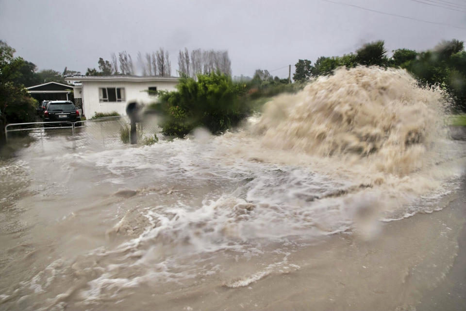 CORRECTS TO SOUTHEAST, NOT SOUTHWEST - Water gushes from a storm drain access port on a street in Te Awanga, southeast of Auckland, New Zealand, Tuesday, Feb. 14, 2023. The New Zealand government declared a state of emergency across the country's North Island, which has been battered by Cyclone Gabrielle. (Warren Buckland/Hawkes Bay Today via AP)